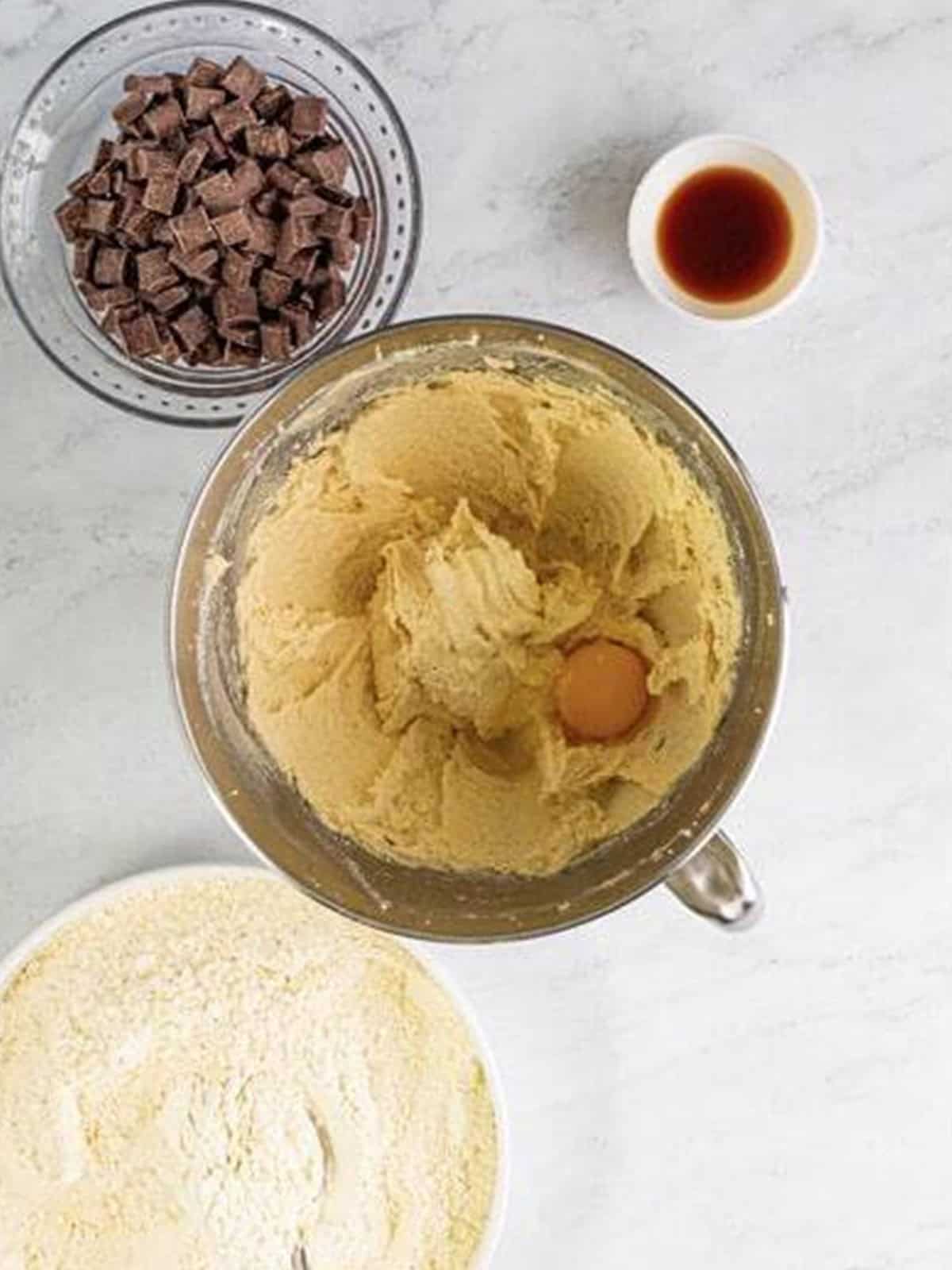 An egg and vanilla added to the creamed butter and sugar for chocolate chunk cookies.