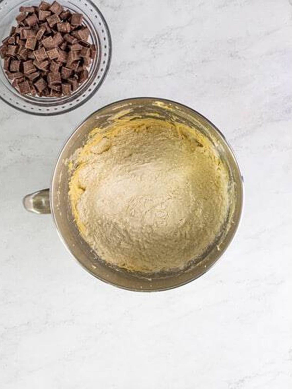 Dry ingredients mixed into the cookie dough in a mixer bowl.