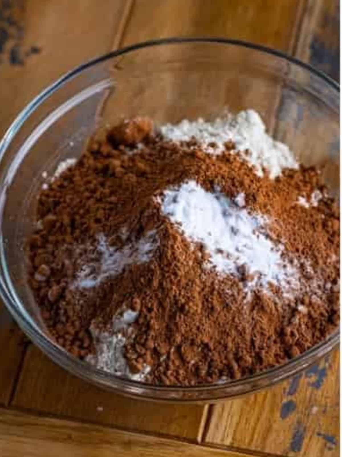 Flour, cocoa powder, and baking soda in a bowl for chocolate cookie bars.