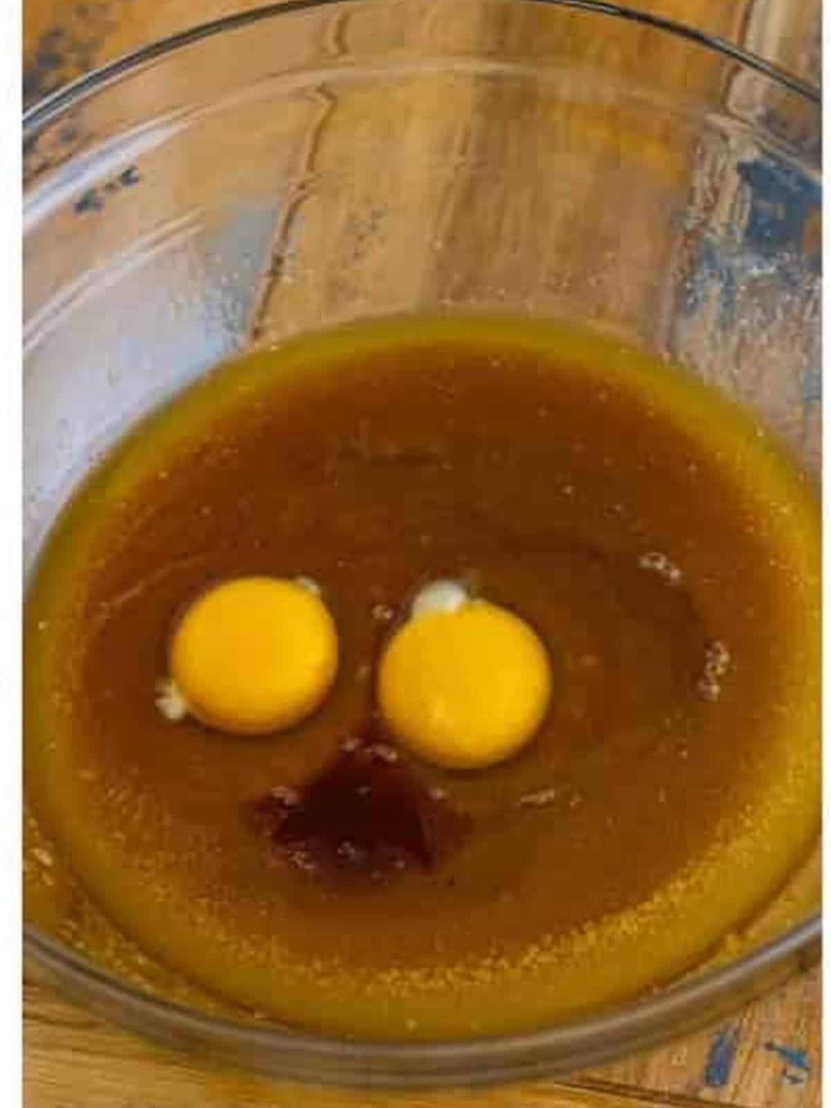 Adding eggs and vanilla to the butter and sugar for chocolate cookie bars.