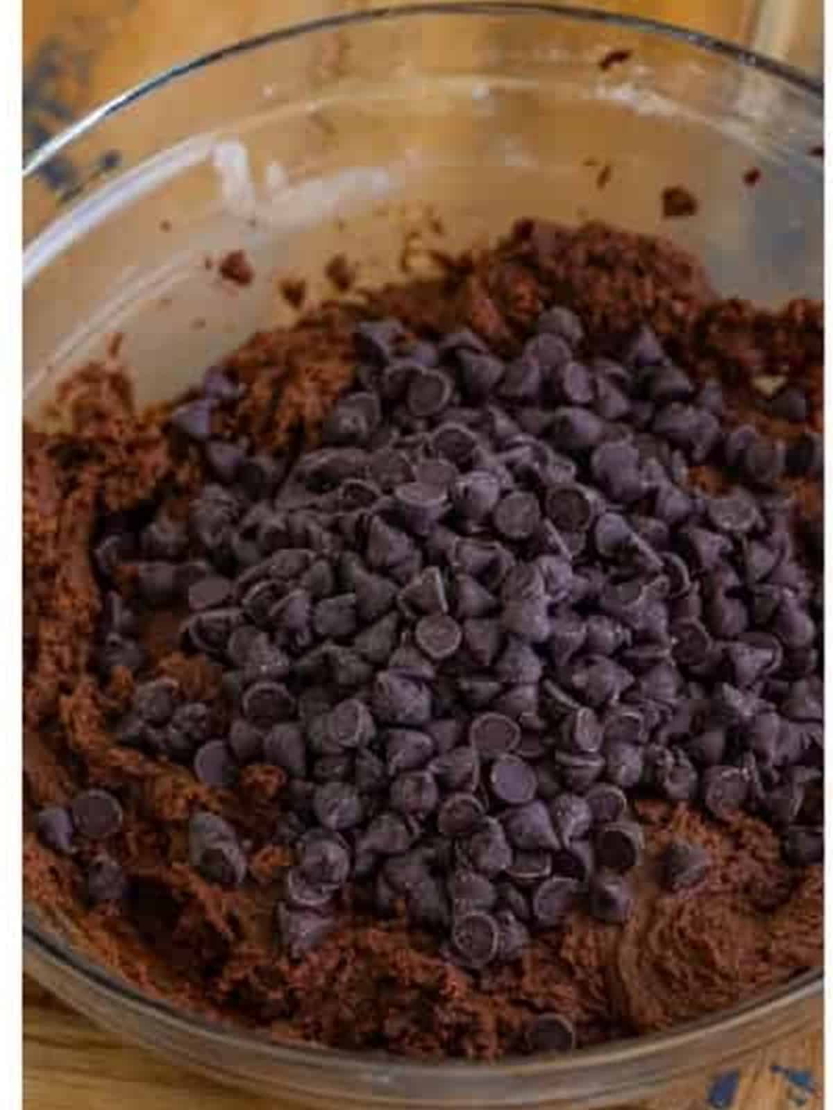 Folding semi sweet chocolate chips into the thick cookie bar dough.