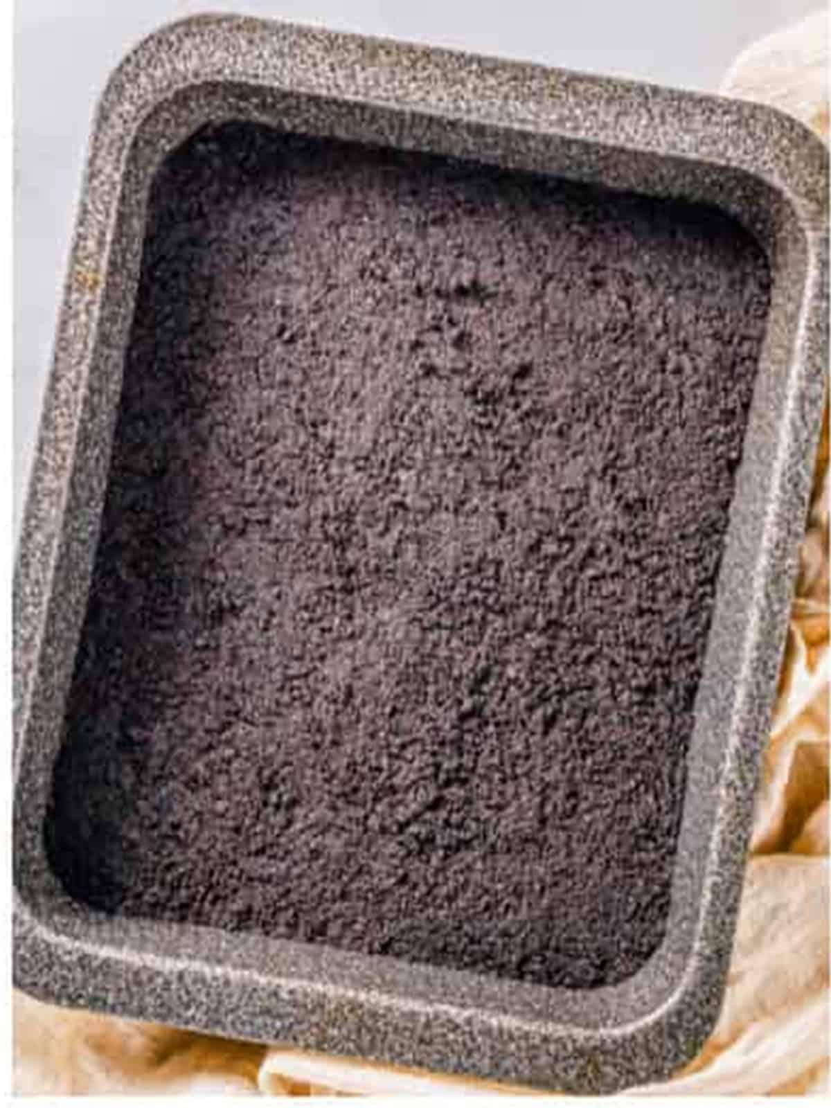 Chocolate sandwich cookie crust pressed into the bottom of a baking dish.