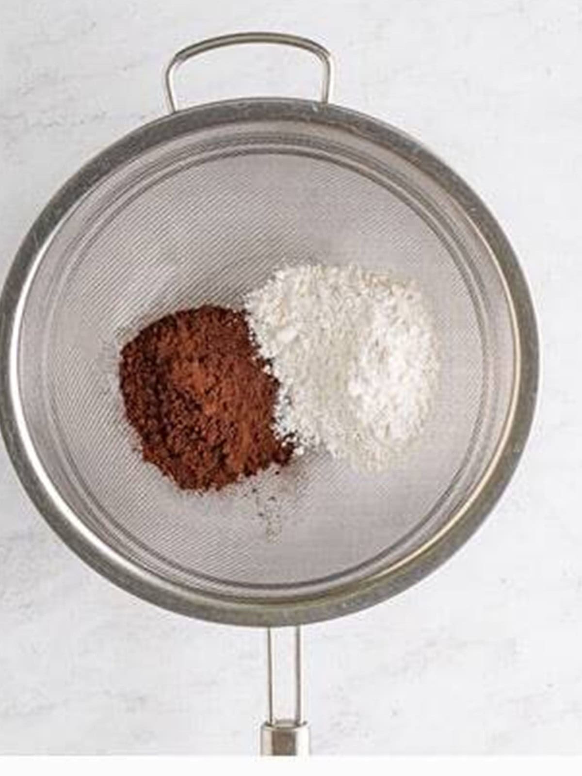Cocoa powder and powdered sugar in a sifter for chocolate mousse.