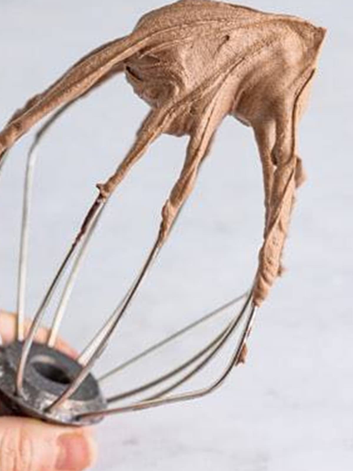 A whisk lifting stiff chocolate whipped cream for chocolate mousse.