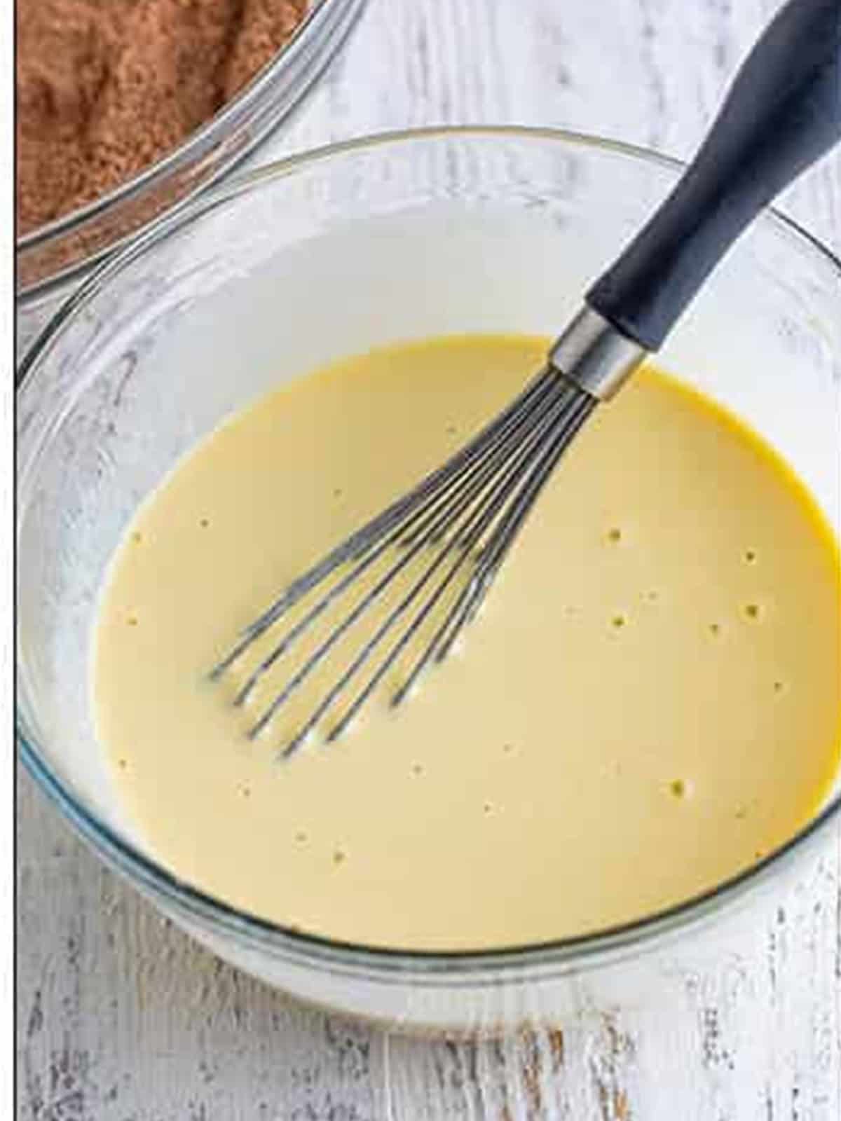 Eggs, oil, sour cream, milk, and vanilla whisked smooth in a bowl.