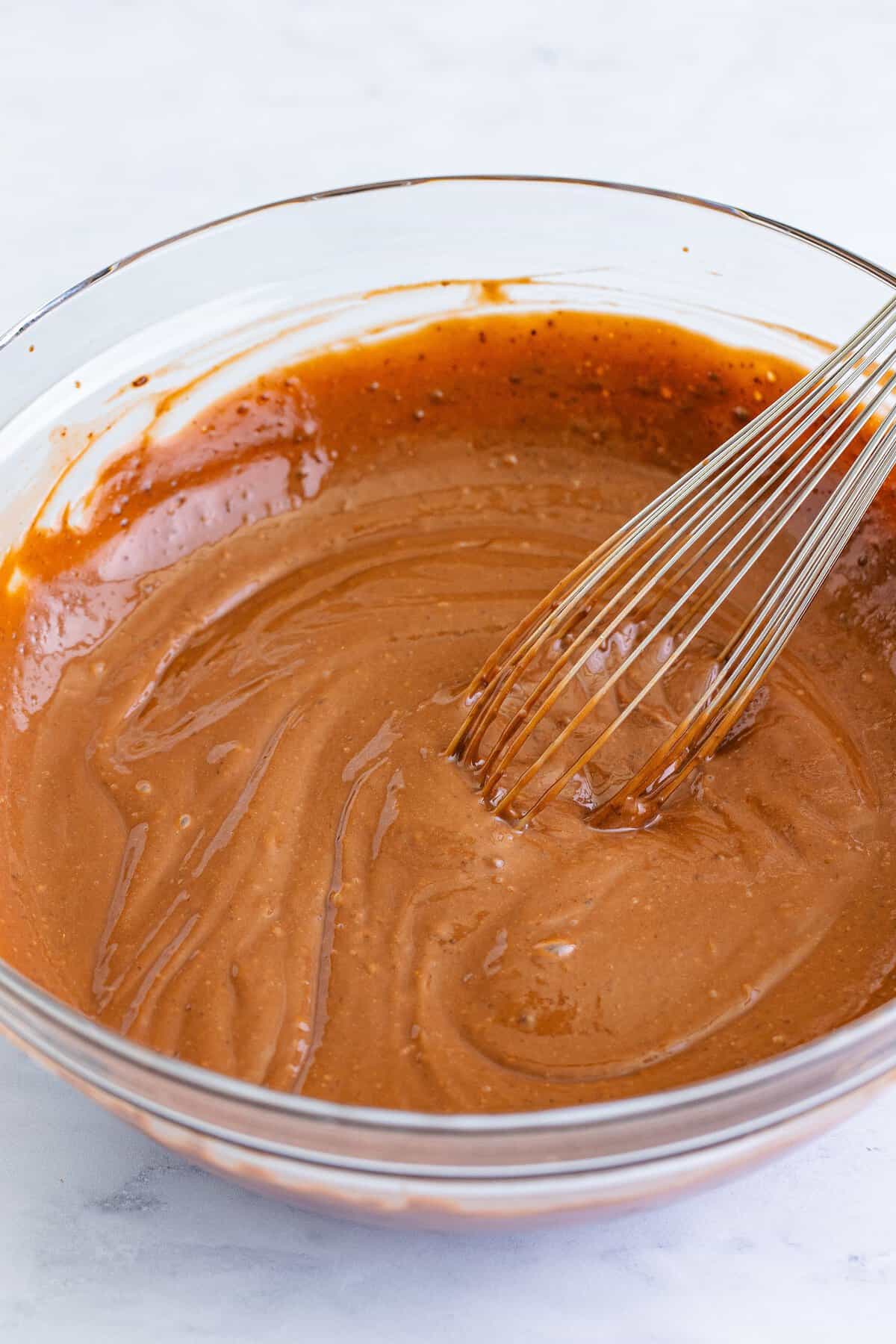 Whisking instant chocolate pudding mix with milk for chocolate peanut butter pie.