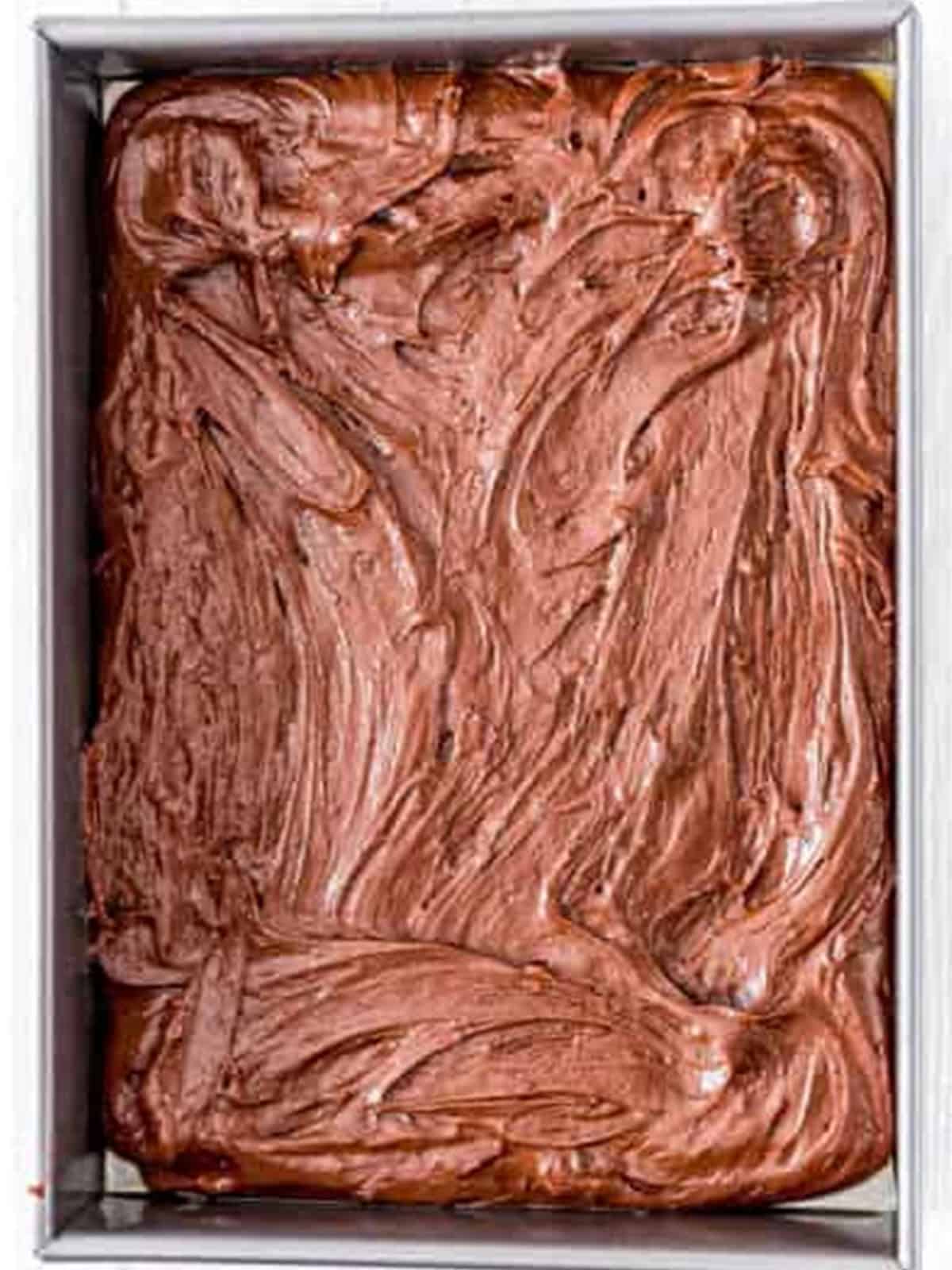 Chocolate poke cake batter spread in a baking pan.