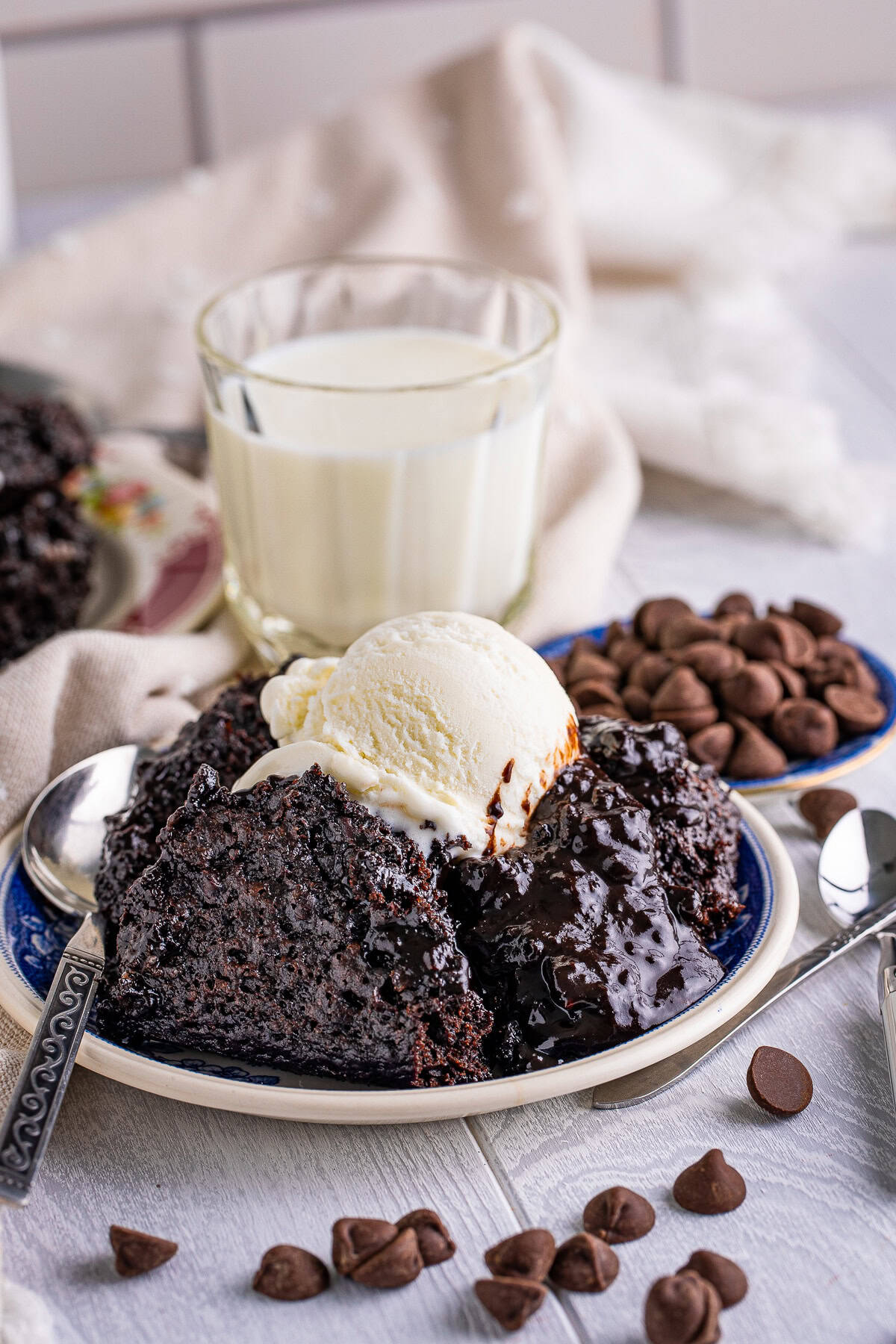 Chocolate pudding cake served with melting vanilla ice cream and a glass of milk.