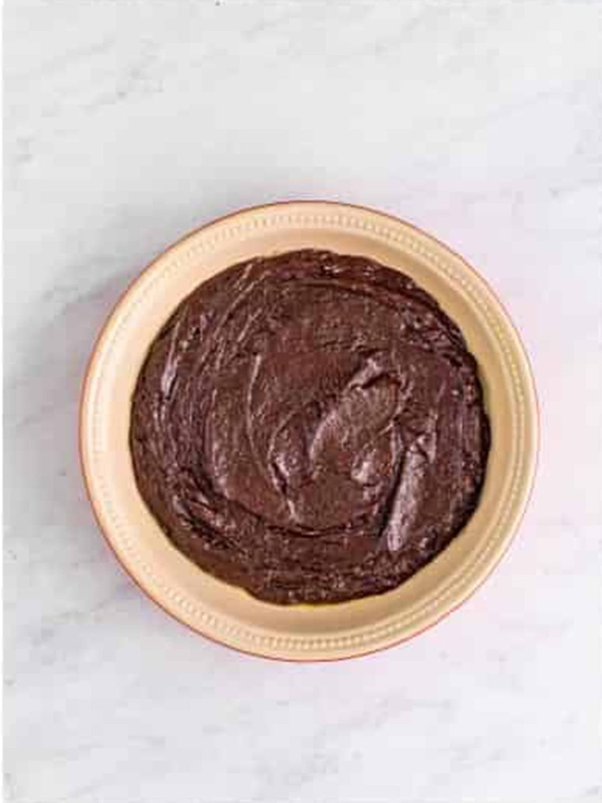 Chocolate cake batter spread into a baking dish.