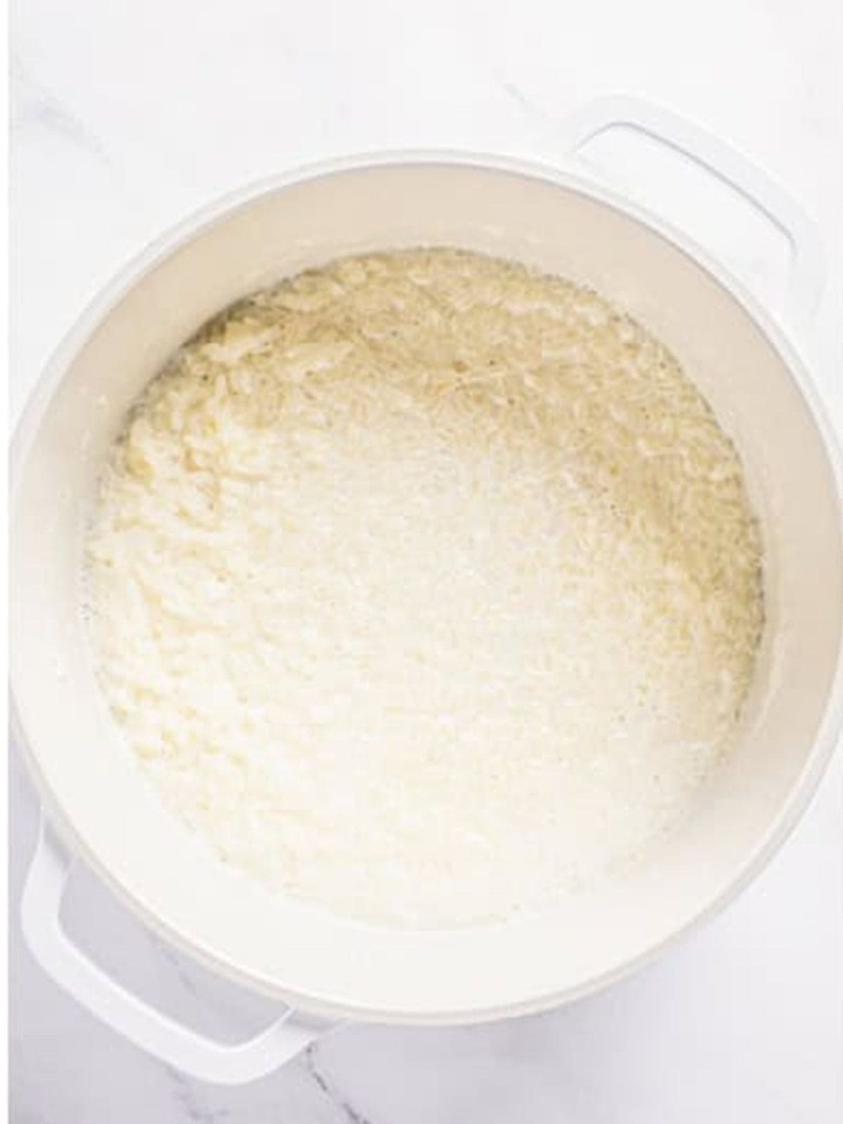 Instant rice cooking in milk in a pot for chocolate rice pudding.