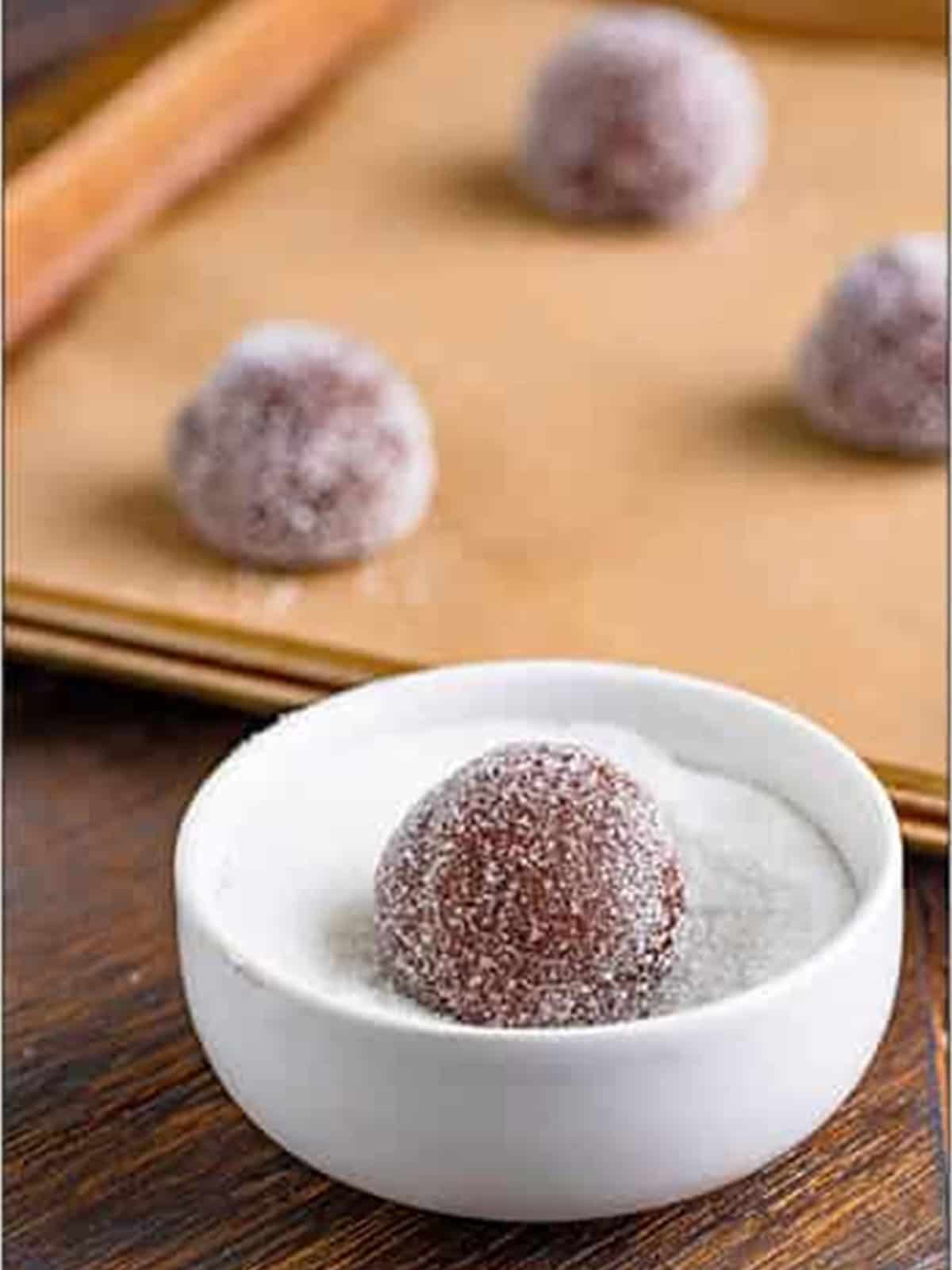 A chocolate cookie dough ball rolled in granulated sugar to coat.