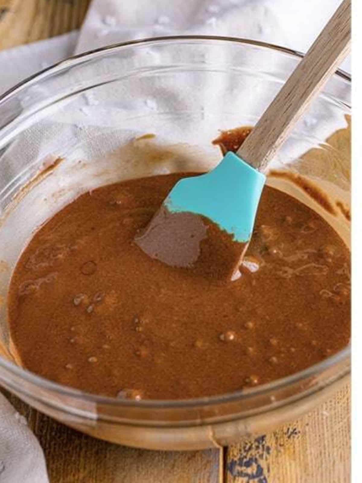 Chocolate cake batter mixed in a glass bowl.