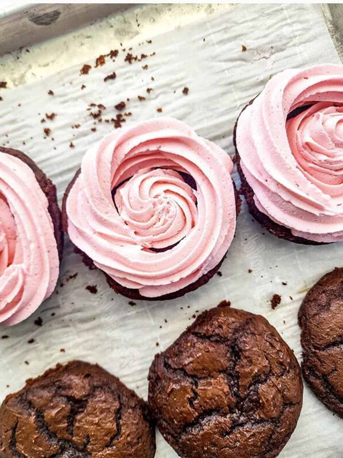Assembled chocolate whoopie pies filled with swirled strawberry frosting.