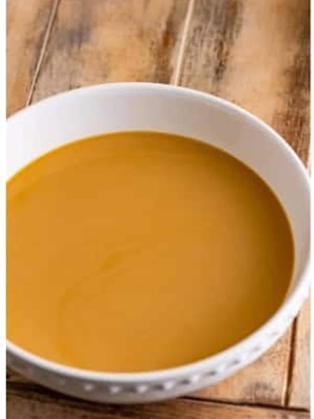 Brewed coffee and coffee creamer stirred together in a bowl for dipping cookies.