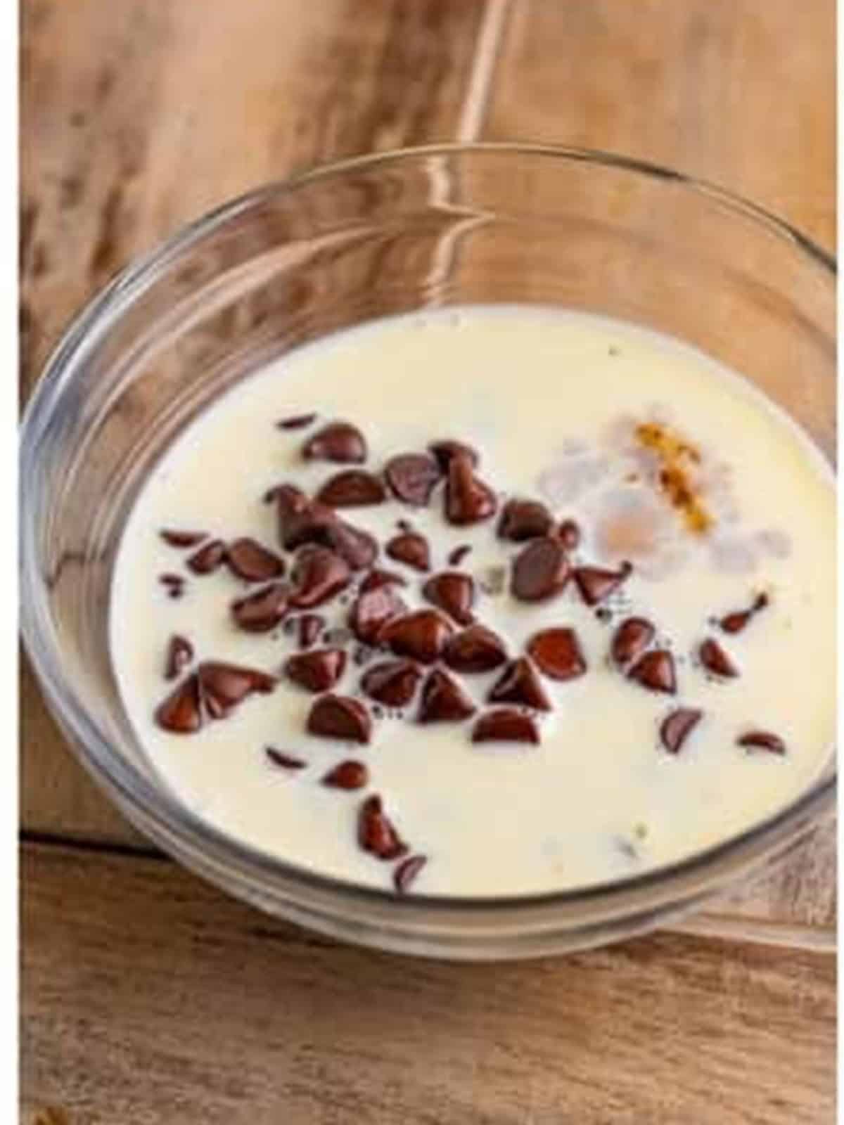 Chocolate chips and hot heavy cream in a bowl to make the ganache topping.