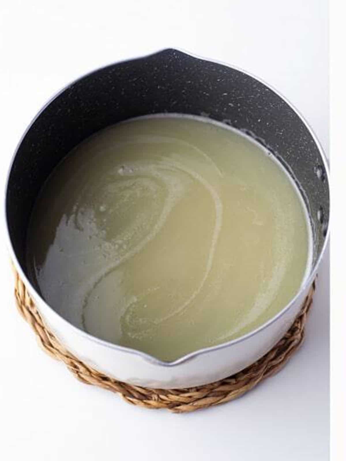Water, butter, and sugar boiling in a saucepan to start churro dough.