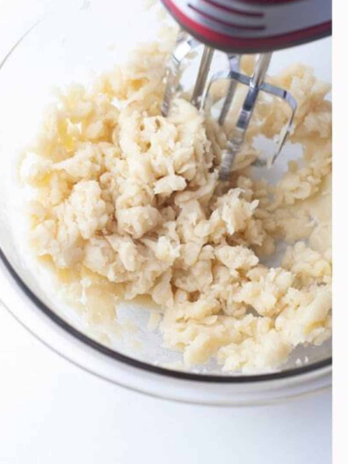 Churro dough beaten in a mixing bowl to cool before adding eggs.