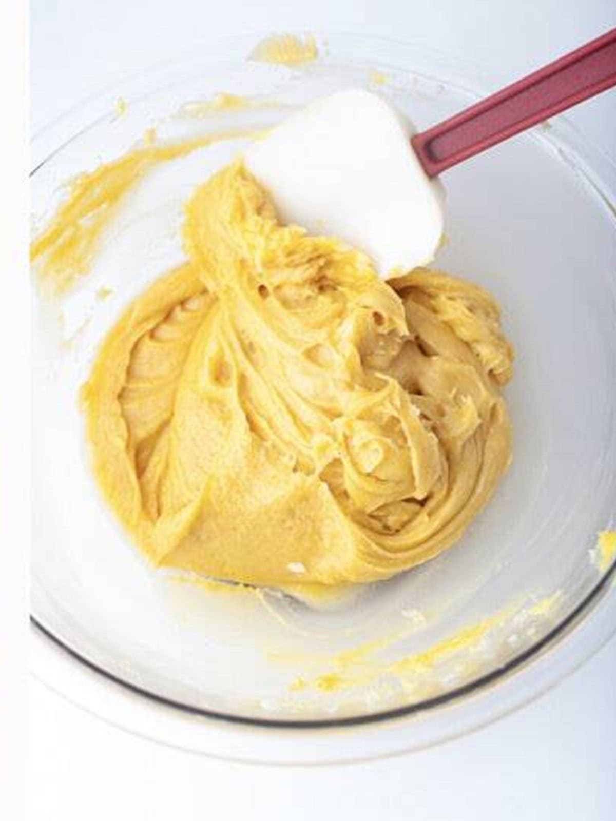 Smooth glossy churro dough mixed with cinnamon in a bowl.