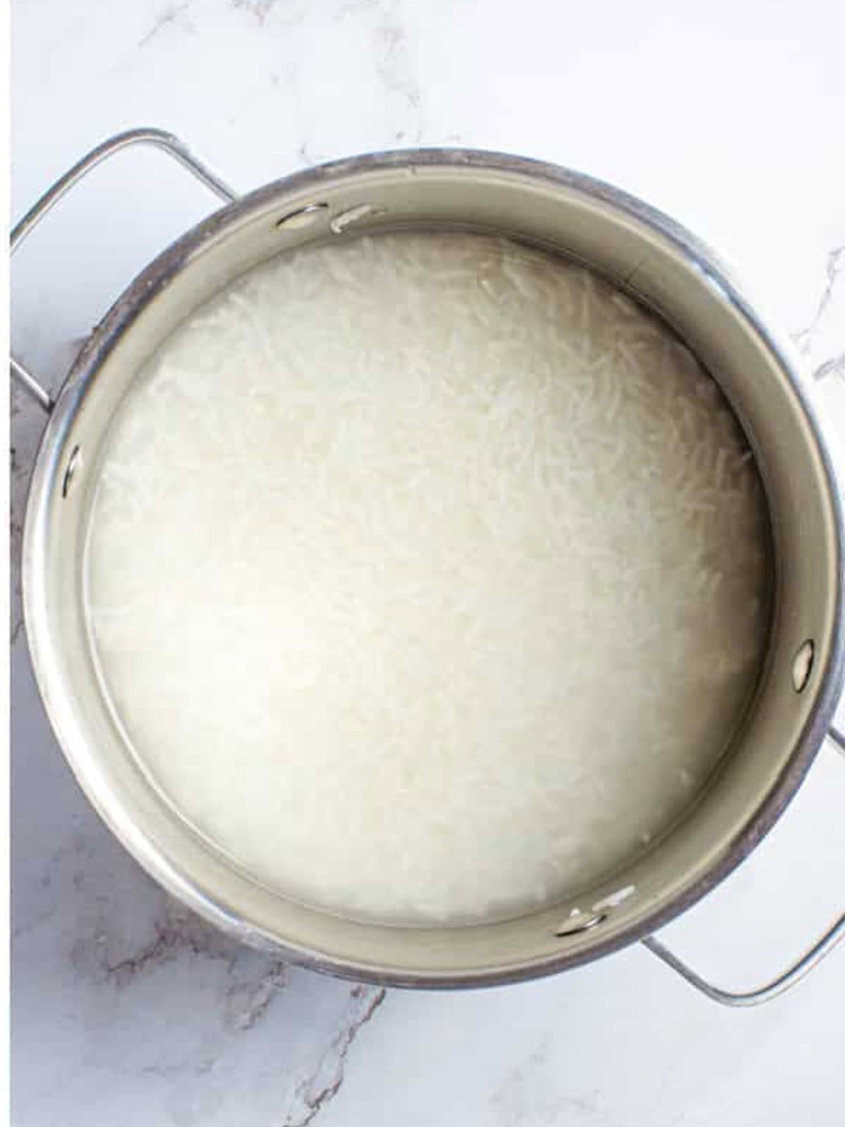 Cooked long-grain white rice in a pot for cilantro lime rice.