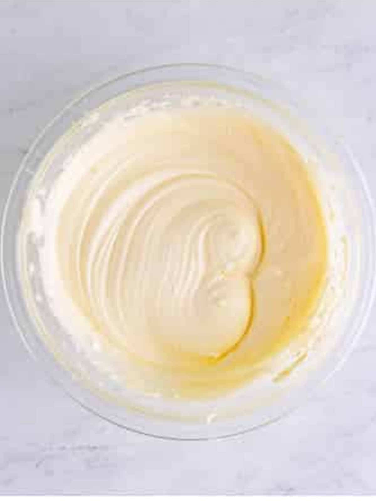 Whipped cream cheese icing in a glass bowl for the blondies.