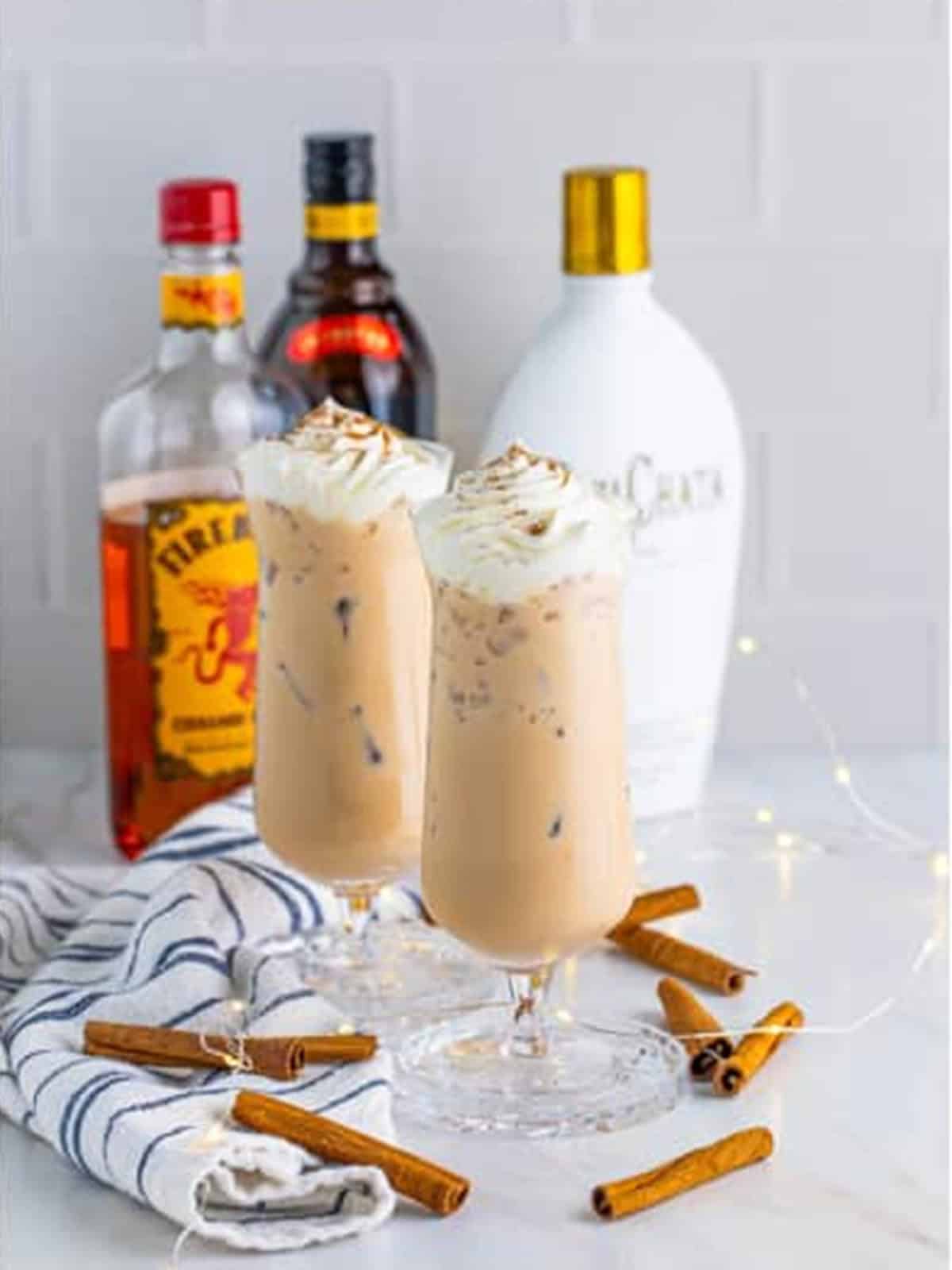 Finished cinnamon roll cocktails topped with whipped cream and ground cinnamon.