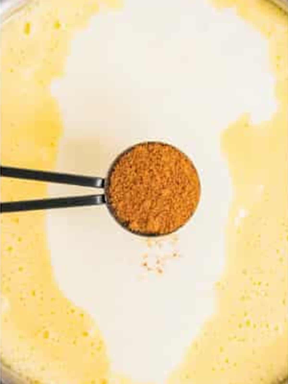 Freshly grated nutmeg being stirred into the finished eggnog.
