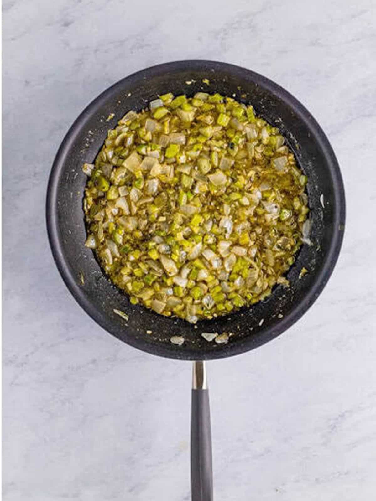 Sauteed celery and onion with sage, thyme, and herbs stirred into the skillet.