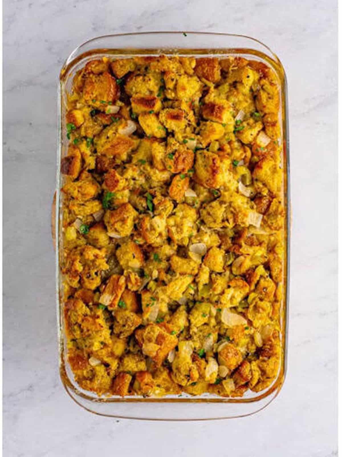 Golden brown baked classic stuffing in a glass baking dish.