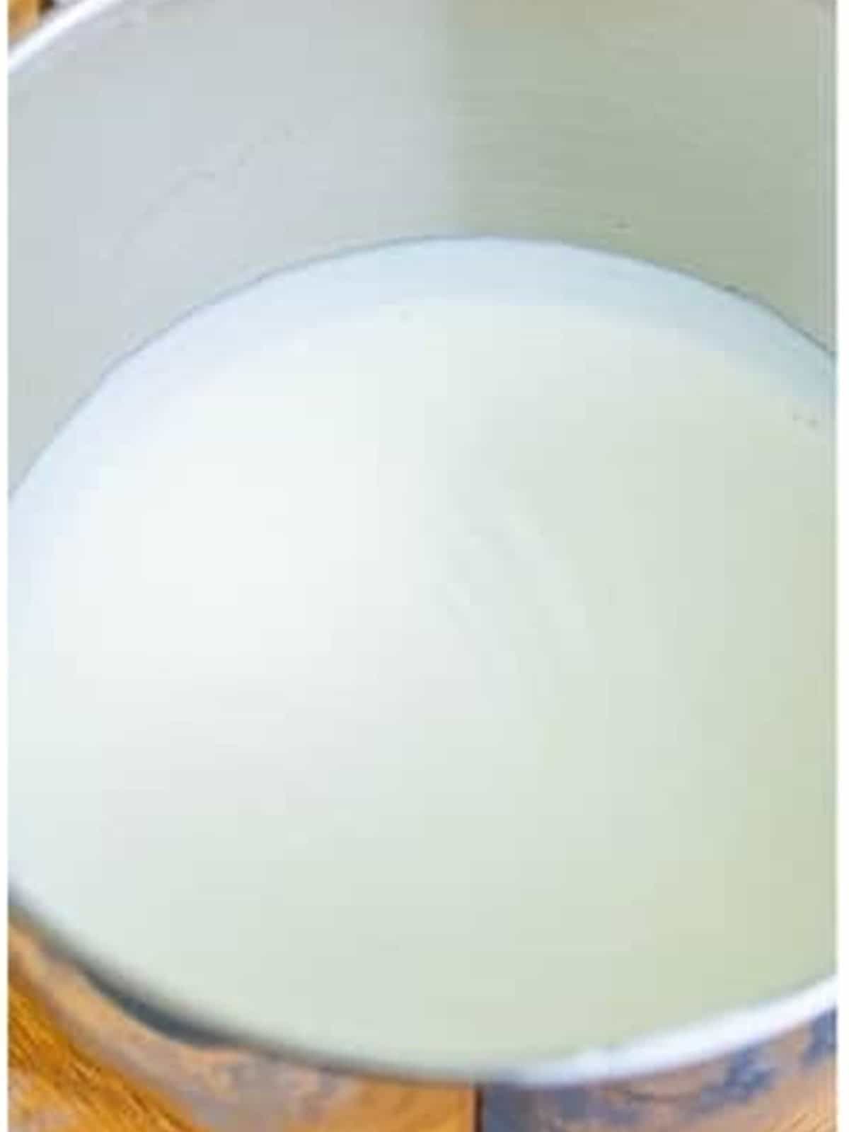 Heavy whipping cream beaten to soft peaks in a metal bowl for Coconut Ice Cream.