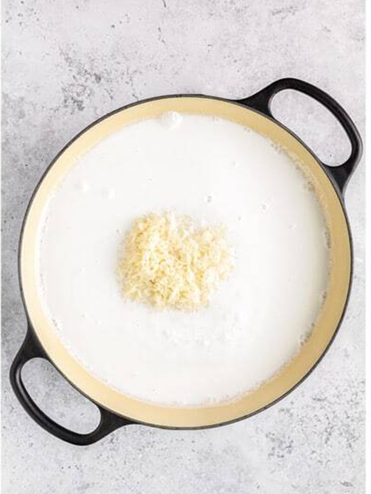 Jasmine rice added to a pot of boiling coconut milk and water.