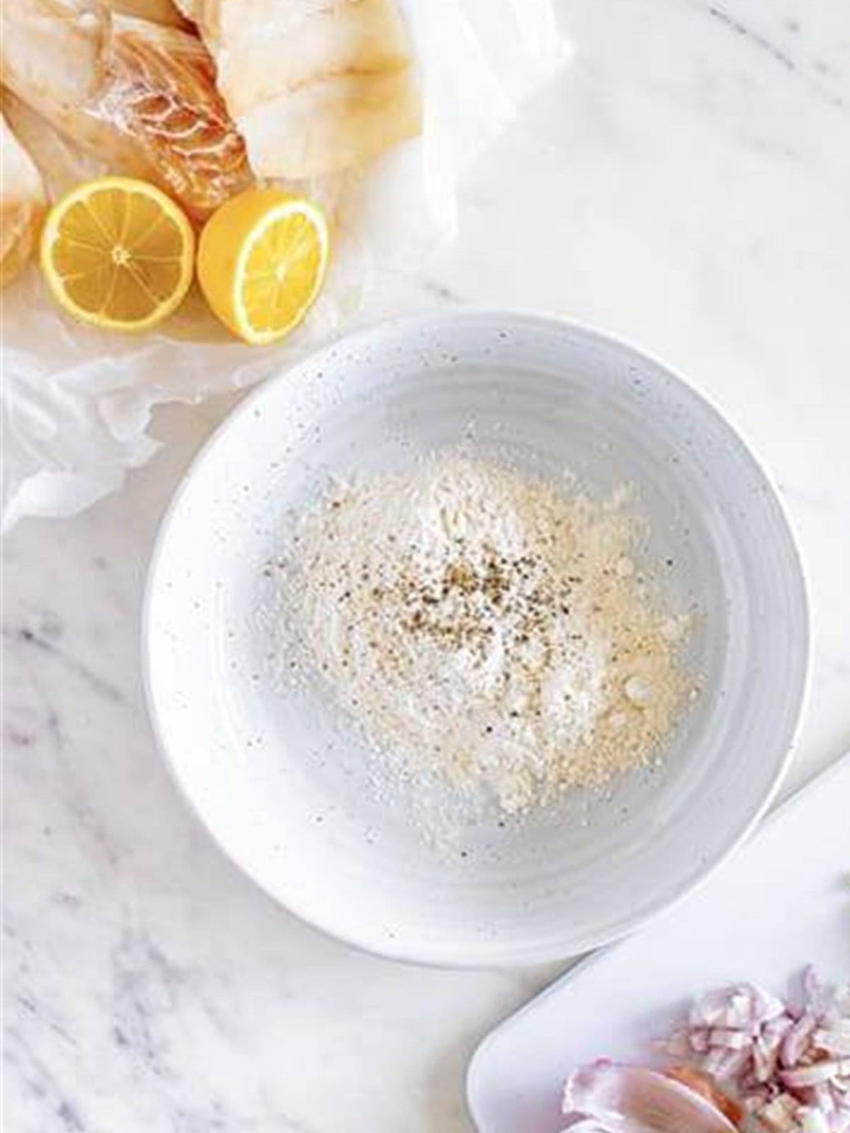 Flour, salt, and pepper mixed in a bowl to dredge cod for cod piccata.