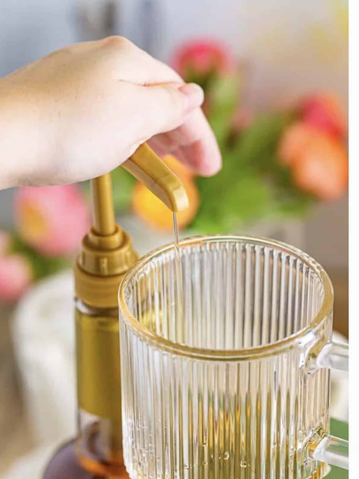 Pumping coffee syrup into an empty mug for a hot coffee.
