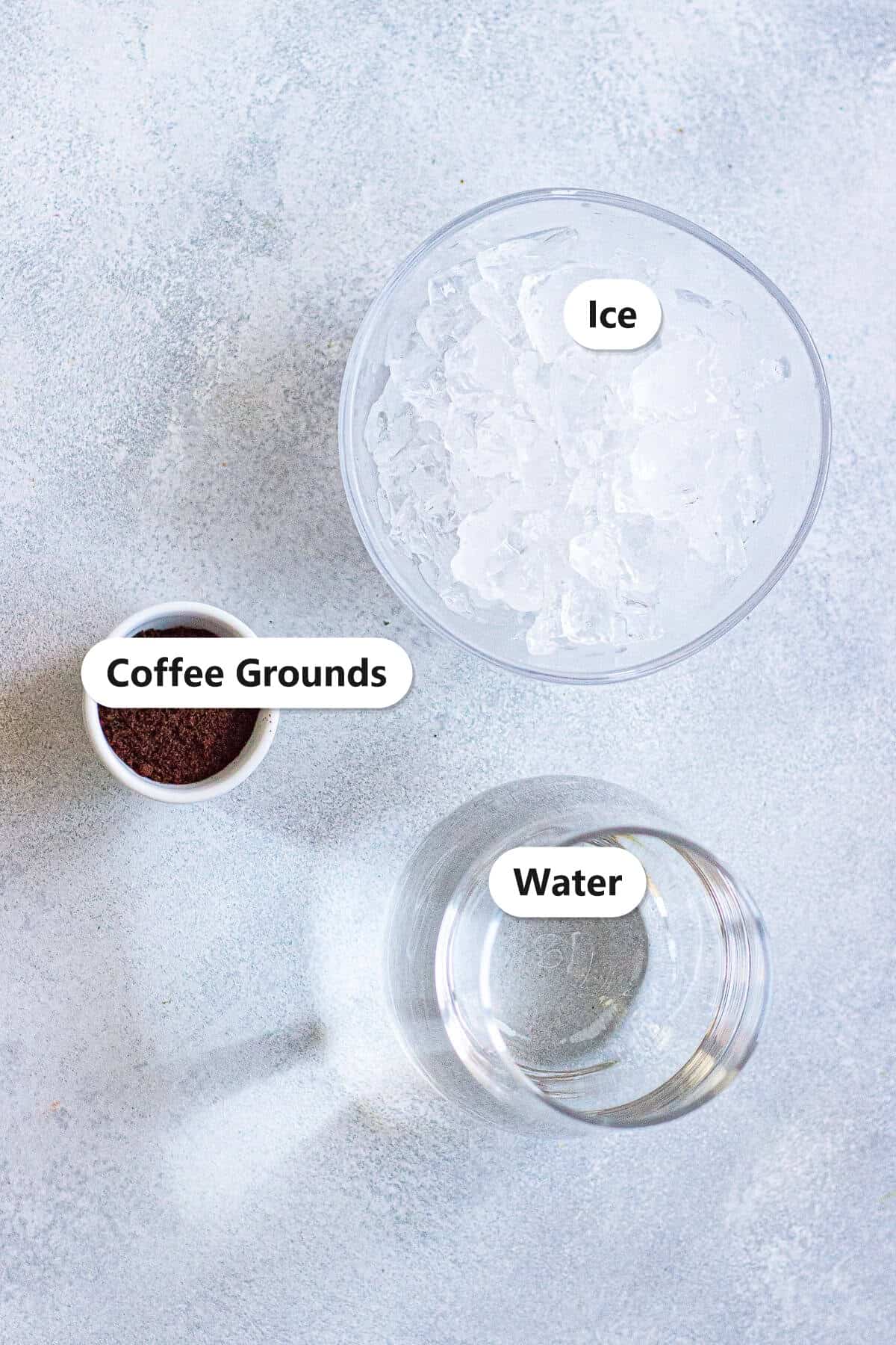 Labeled ingredients for cold brew coffee including coarse coffee grounds, water, and ice.