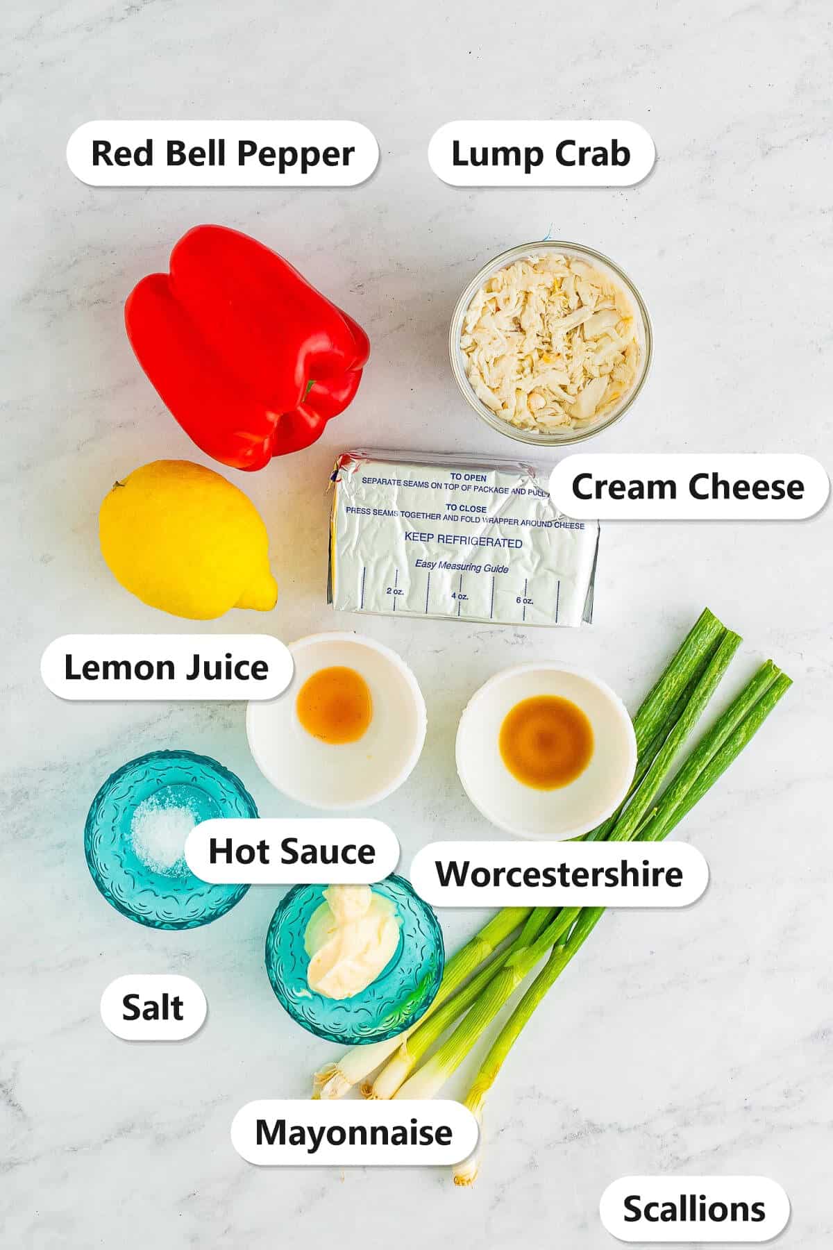 Labeled ingredients for cold crab dip recipe including lump crab, cream cheese, mayonnaise, scallions, red bell pepper, lemon juice, and seasonings.