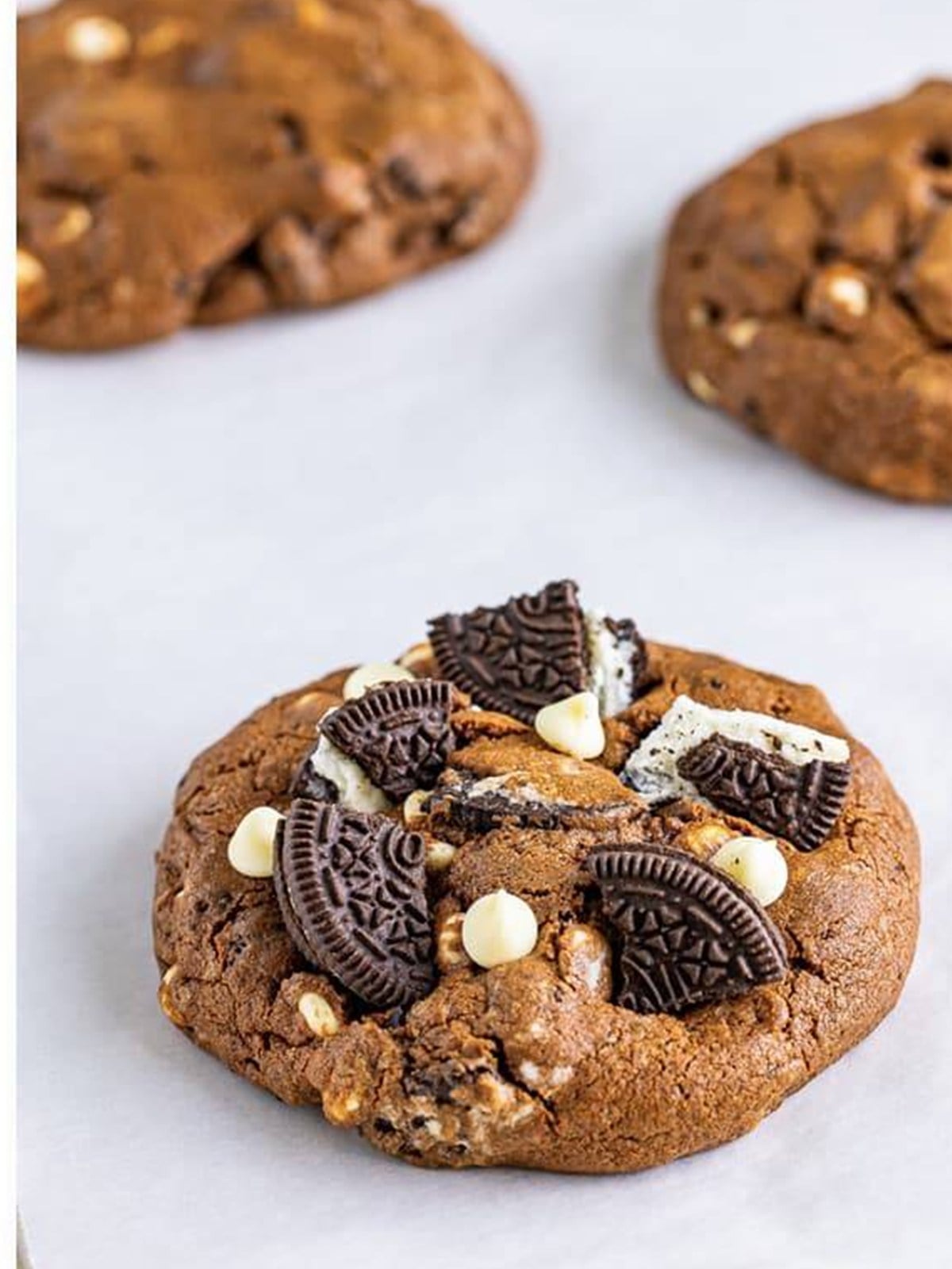Finished cookies and cream cookies with extra Oreo pieces and white chocolate chips pressed on top.