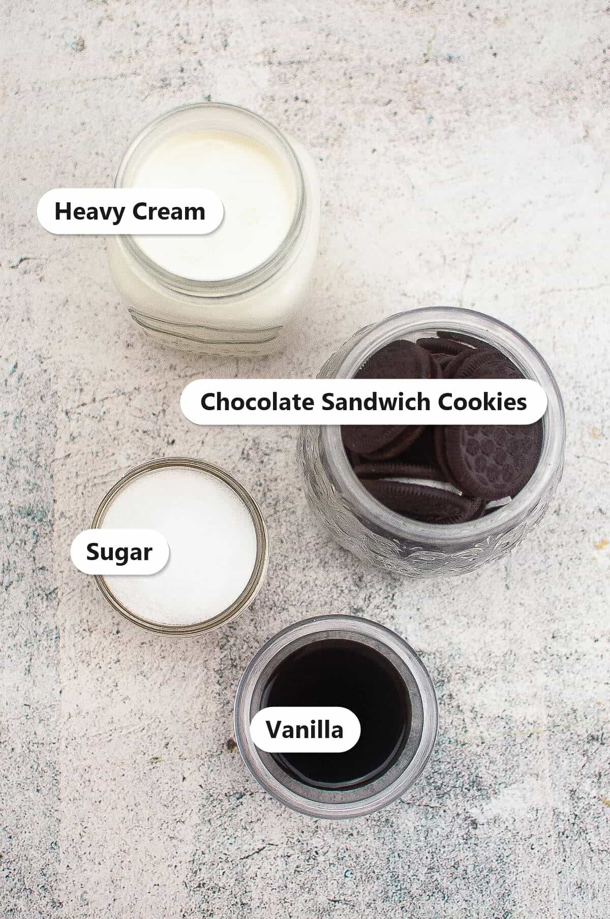 Labeled ingredients for no churn Cookies and Cream Ice Cream including heavy cream, chocolate sandwich cookies, sugar, and vanilla.