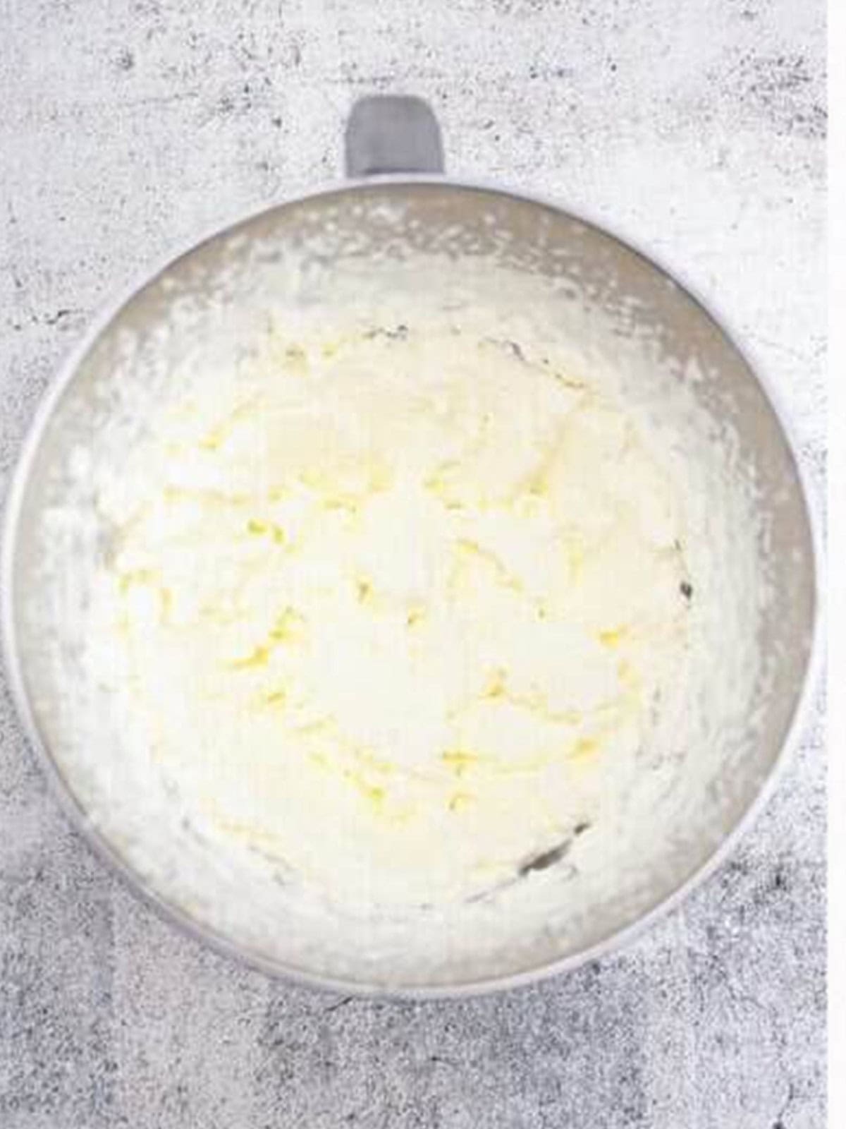 Heavy cream whipped to soft peaks in a metal bowl.