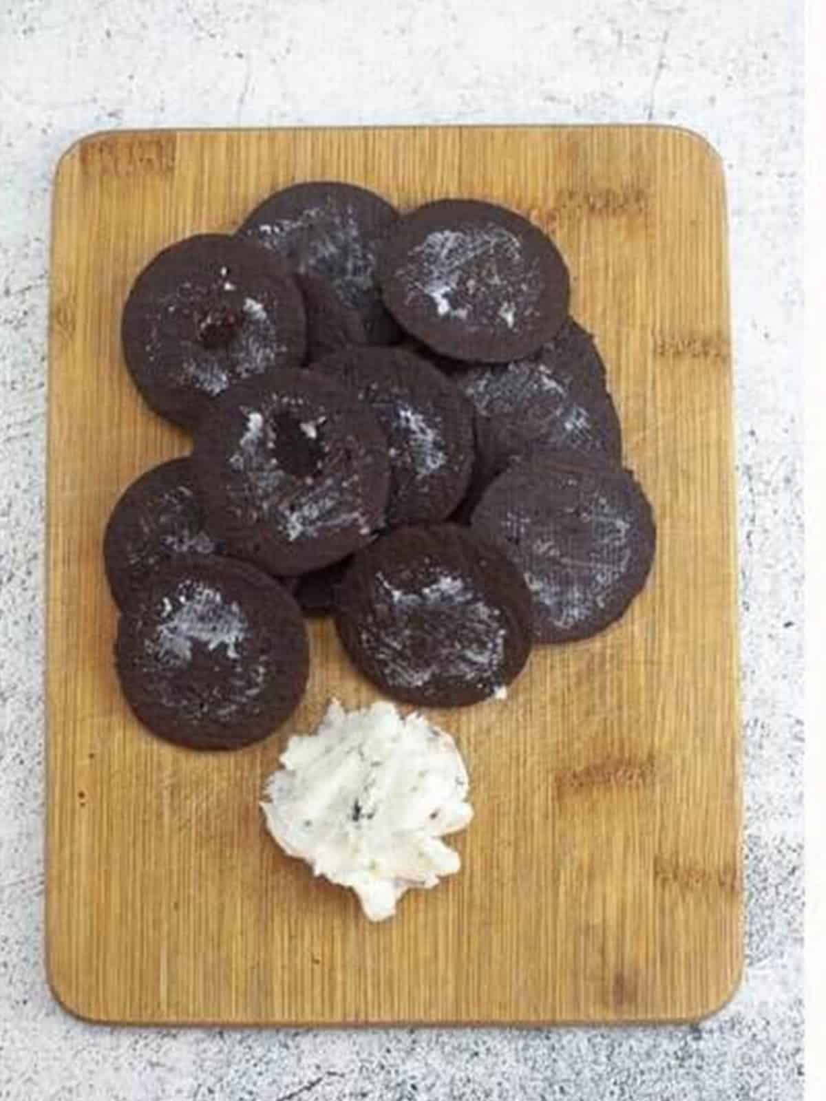 Chocolate sandwich cookies on a board with the cream filling scraped out.