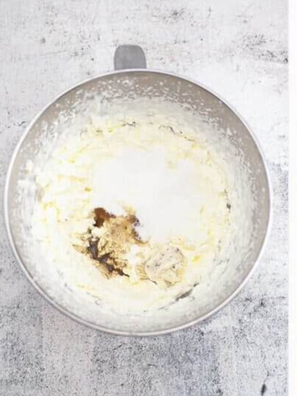 Folding sugar, vanilla, and cookie filling into the whipped cream.
