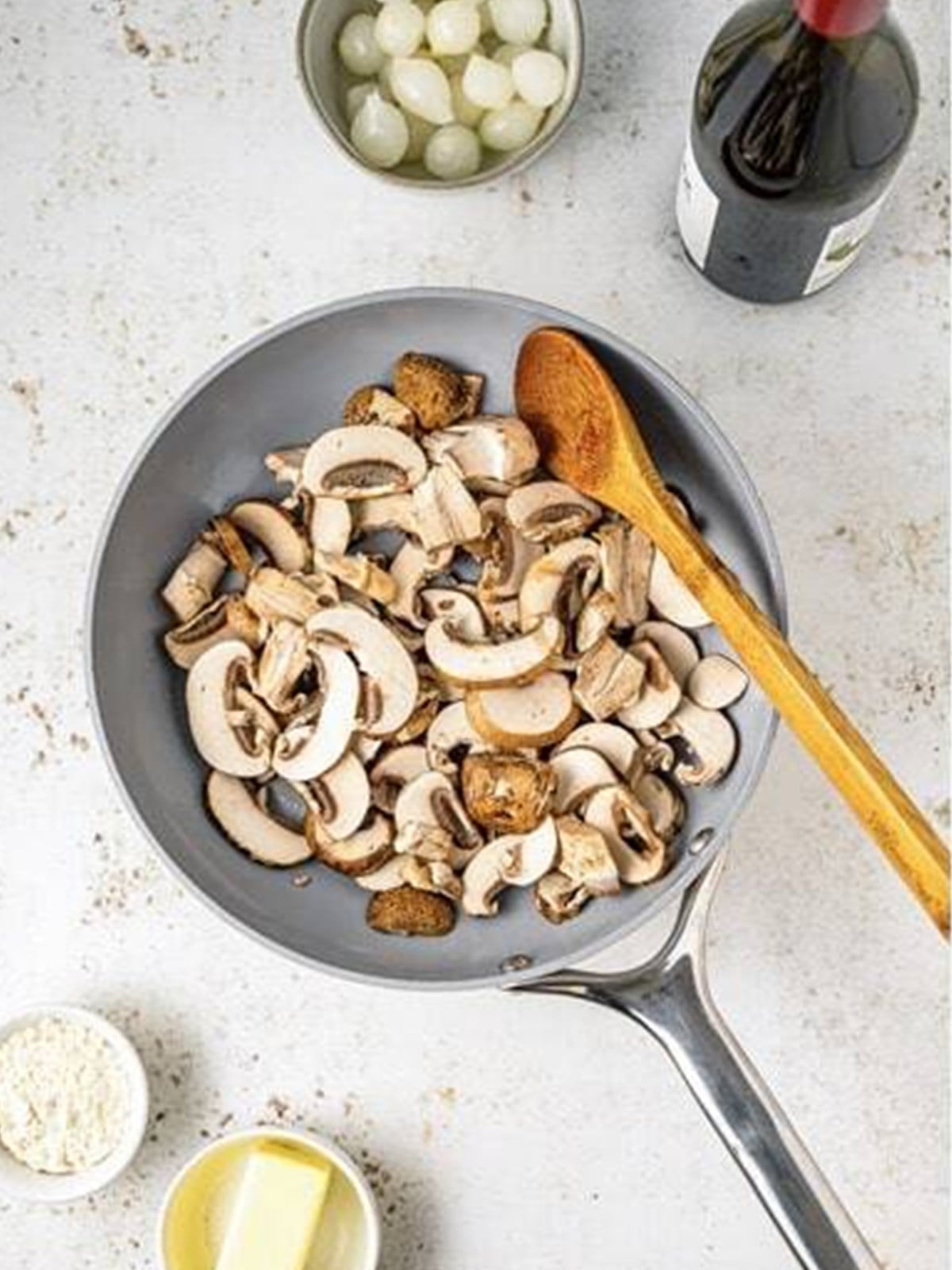 White button mushrooms browning in a separate pan for coq au vin.