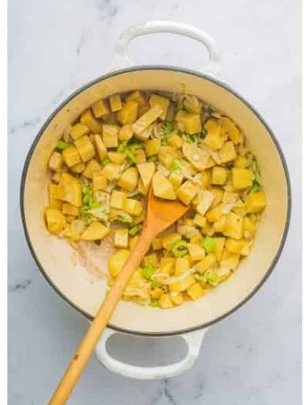 Sauteing diced potatoes, onion, and celery in bacon fat for corn chowder.