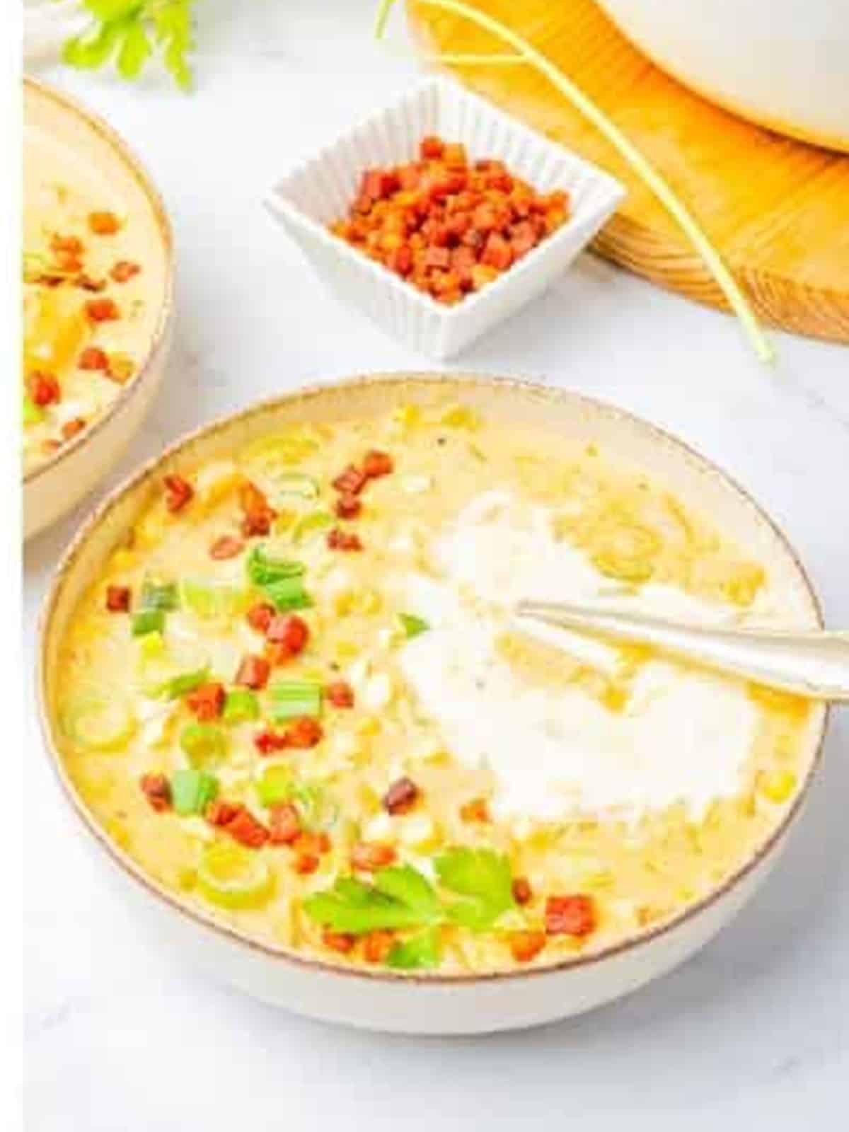 Finished corn chowder garnished with crispy bacon and green onion.