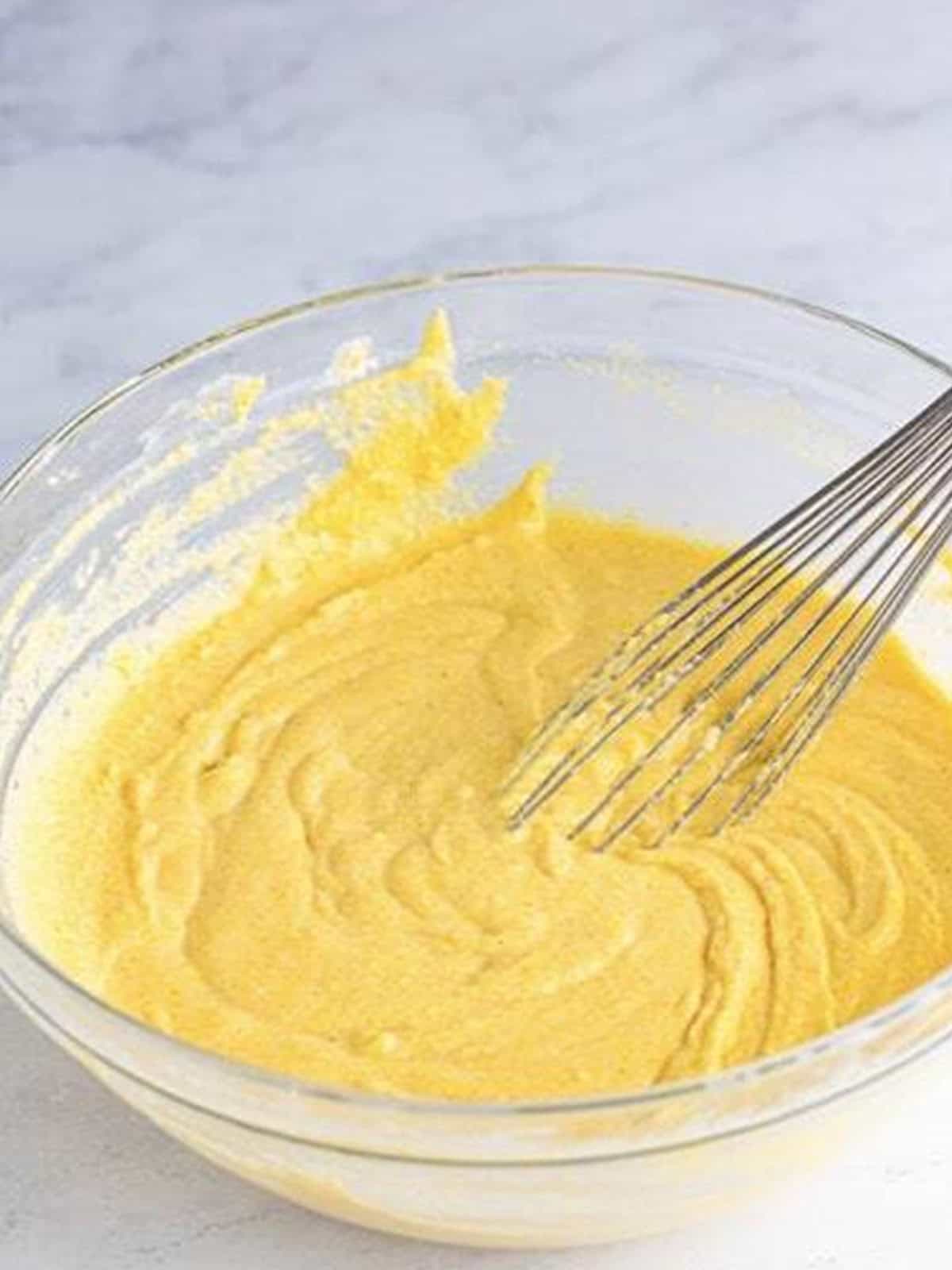 Smooth cornmeal corn dog batter whisked in a bowl.