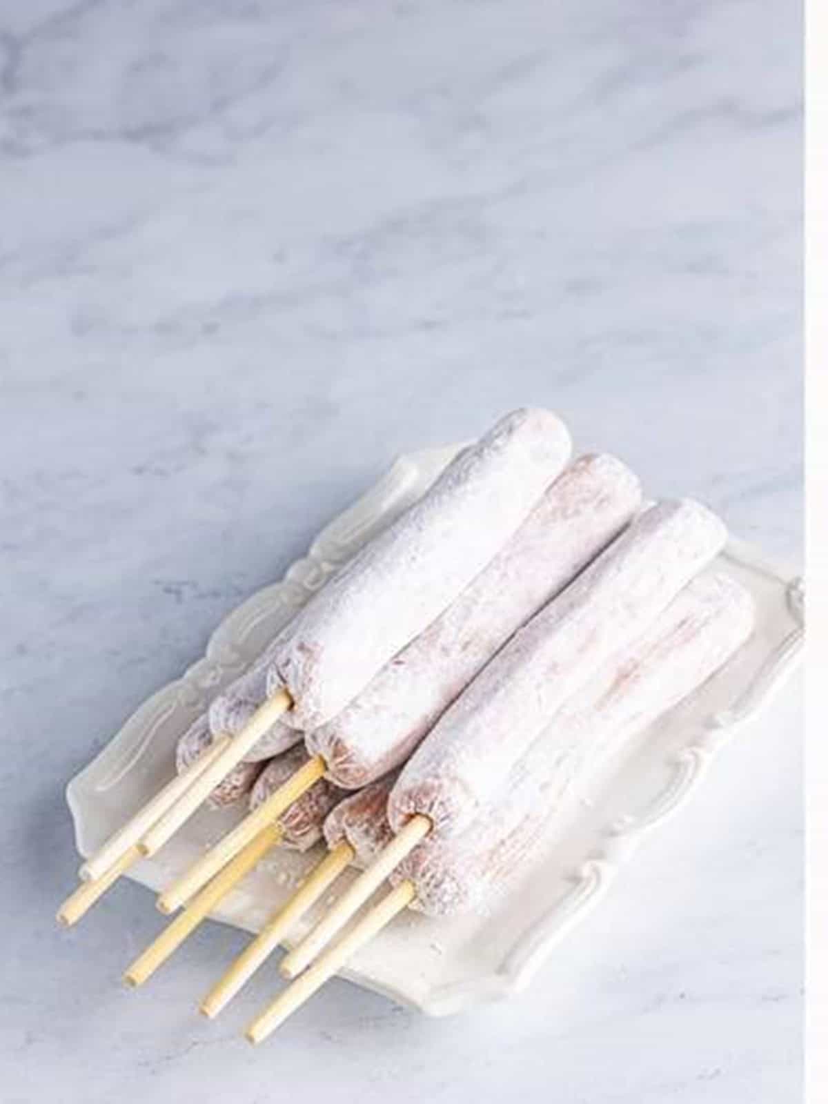 Hot dogs coated in cornstarch and skewered for corn dogs.