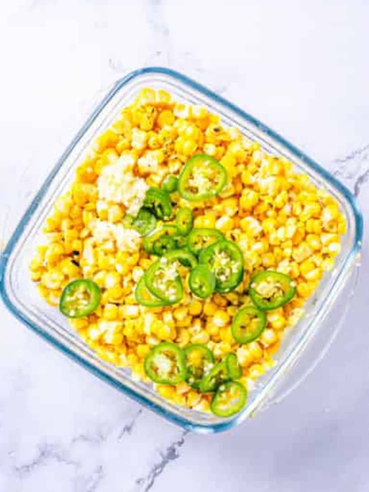 Cut corn with jalapeno and garlic in a container for Corn Relish.