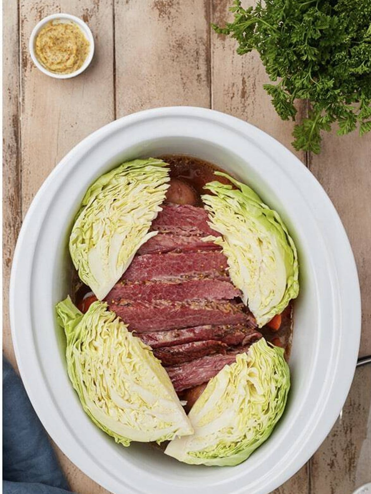 Cabbage wedges added to the slow cooker with the sliced corned beef.