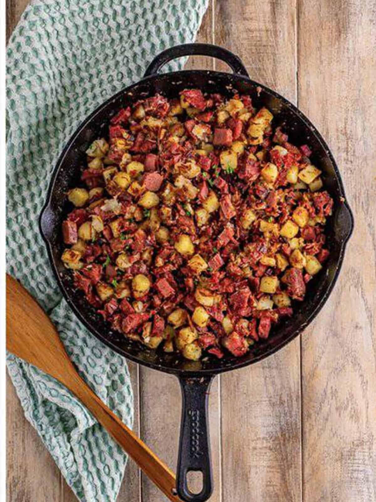 Finished homemade corned beef hash, crispy and golden in a cast iron skillet.