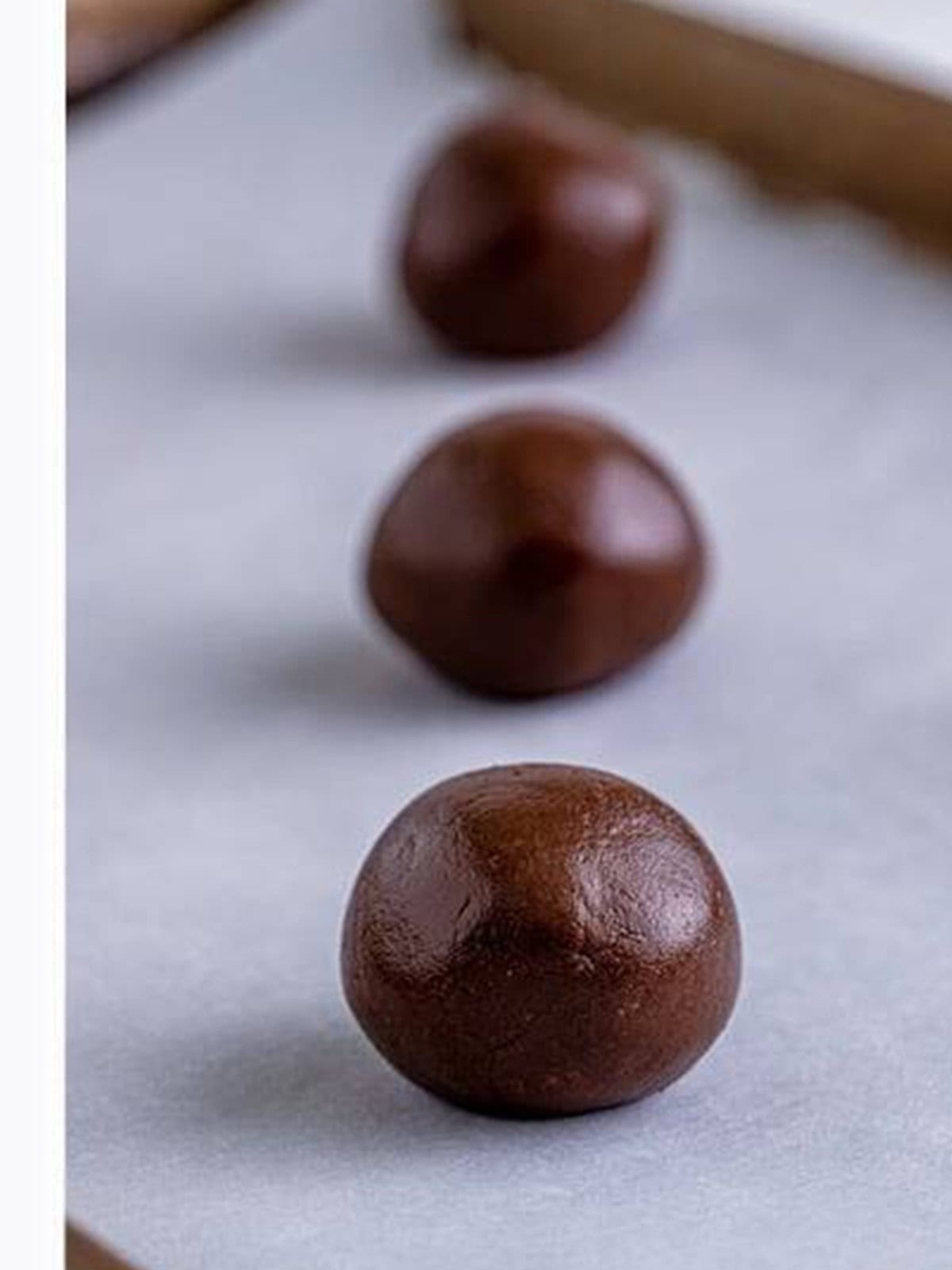 Rolling the brownie cookie dough into balls before chilling.