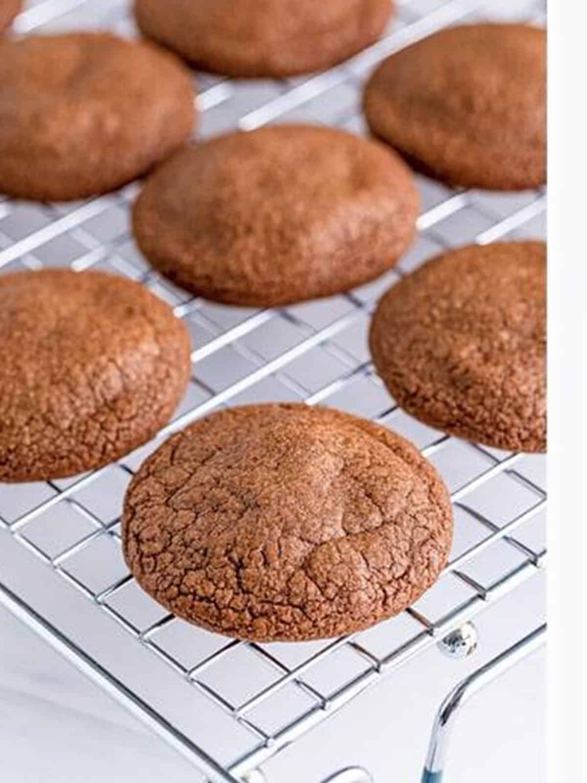 Baked brownie cookies cooling on a wire rack.