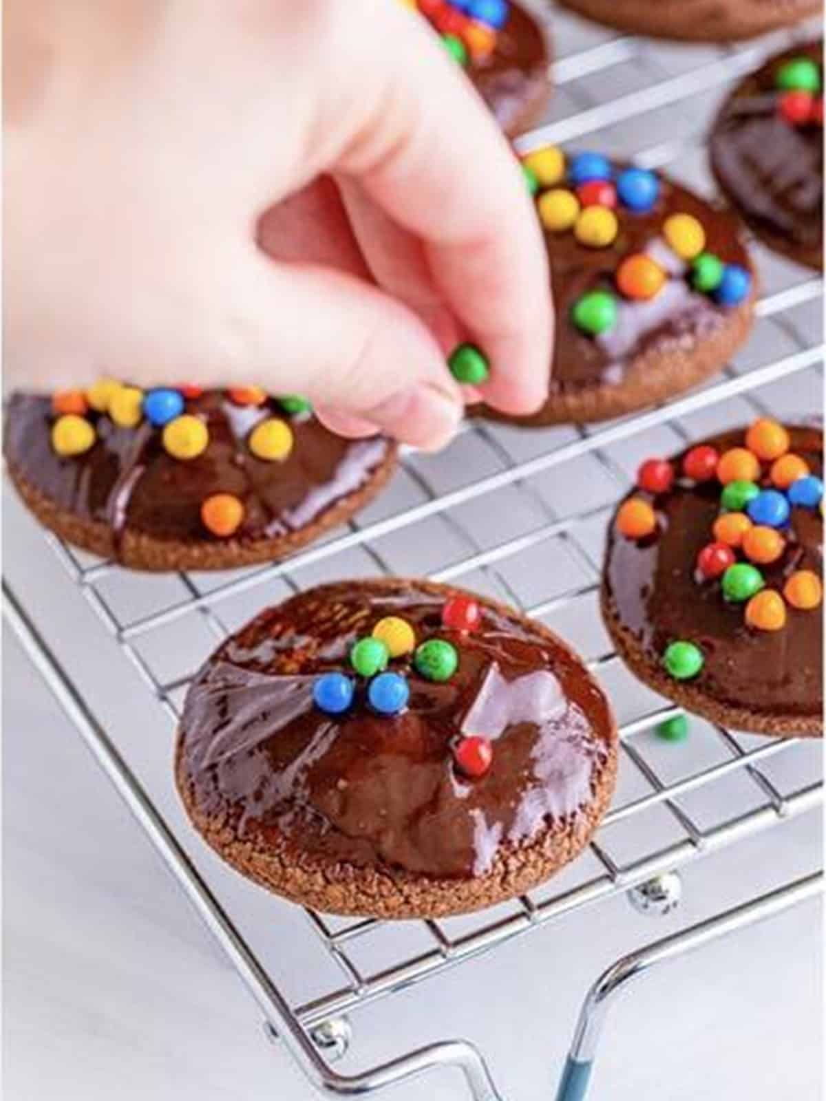 Topping the ganache dipped cookies with rainbow candy chips.